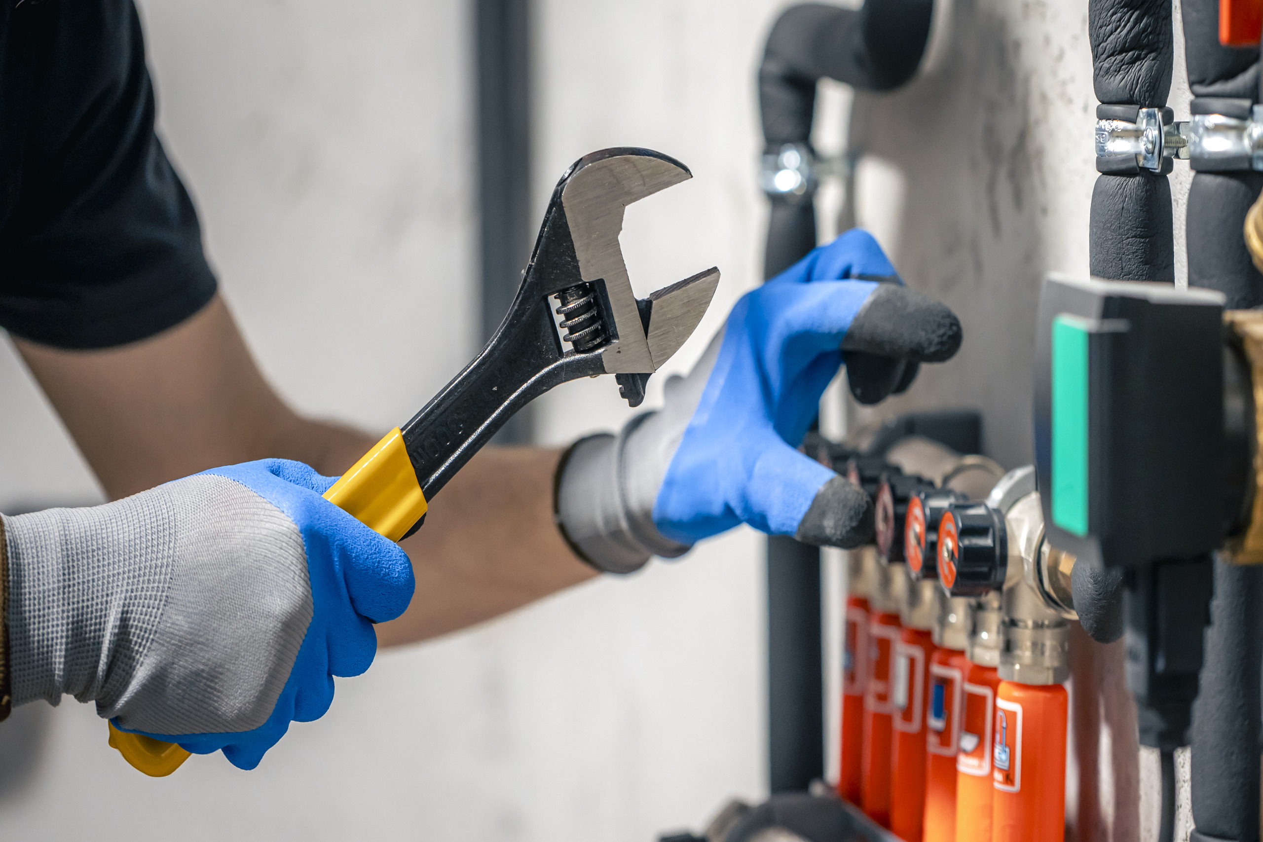 man-installs-heating-system-house-checks-pipes-with-wrench (1)